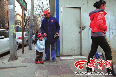 由于沒人照看，爸爸媽媽干活時帶著兩歲多的小韓靈  本報(bào)記者 董國梁 攝 